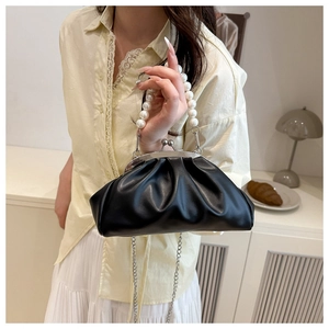 Detail of black pleated cloud bag with elegant pearl handle and vintage metal clasp