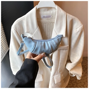 Close-up of a mini light blue pleated crescent bag featuring soft ruffled leather detail
