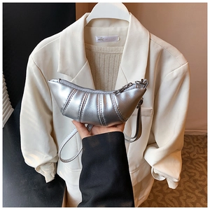Close-up of metallic silver mini croissant bag featuring horizontal pleated texture