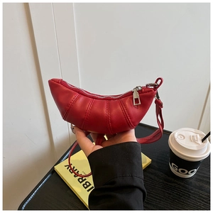 Detail of red leather croissant bag with pleated texture and silver zipper closure