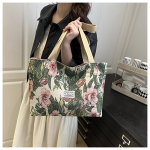 Detail of floral jacquard canvas tote bag featuring pink flowers and woven beige handles