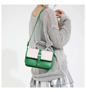 Detail of silver liquid-metal handle and heart-shaped buckle on two-tone shoulder bag