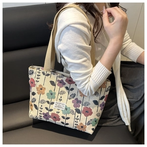 Close-up of a canvas tote bag featuring vintage floral patterns and woven handles