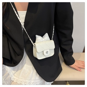 Detail of white quilted mini crossbody bag with silver rose buckle and bow accent