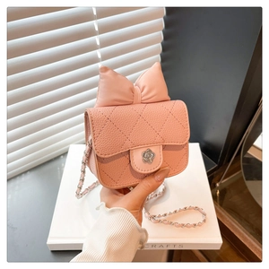 Detail of pink quilted mini bag featuring camellia metal clasp and bow decoration