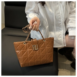 Close-up of brown quilted PU leather tote bag with gold chain handle and metal buckle
