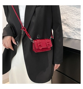 Detail of red mini crossbody bag with glossy finish and matching chunky chain strap