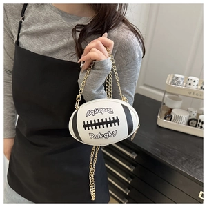 Detailed view of rugby shaped crossbody bag with lychee texture and gold chain strap