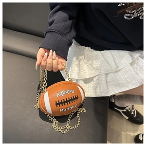 Macro shot of brown rugby ball shaped crossbody bag with gold chain strap details