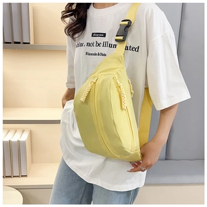 Detail view of bright yellow nylon crossbody bag with dual zippers and adjustable strap
