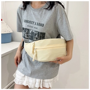 Detailed shot of cream nylon crossbody bag featuring woven rope zipper pulls and straps