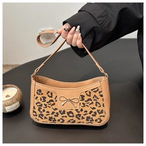 Detail of leopard print shoulder bag with golden metal bow buckle and brown trim
