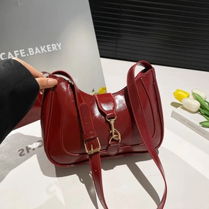 Glossy wine red patent leather saddle bag with gold buckle hardware and adjustable strap
