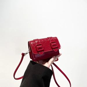 Mini glossy red leather square crossbody bag with dual buckles and slim shoulder strap