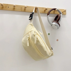 Pale yellow nylon crossbody bag with multi-zipper compartments and adjustable wide strap