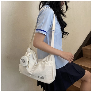 Detailed view of white canvas tote bag with fashion print and mini round pouch attachment