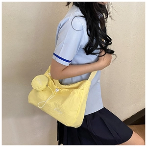 Detail of yellow pleated nylon tote with drawstring and matching round charm bag