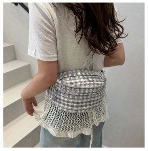 Gray plaid crossbody chest bag with multi-zipper detail on minimalist white stairs