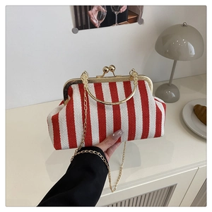 Détail macro du sac à main rayé rouge et blanc avec cadre doré et anse ronde