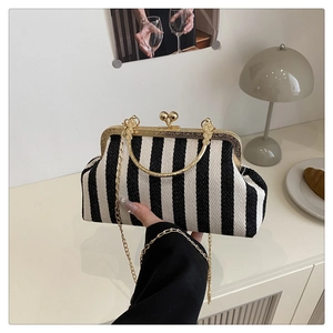 Détail d'un sac à main rayé avec fermoir doré dans un décor de style de vie chic
