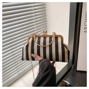 Détail du sac à main à rayures noir et blanc avec fermoir doré et poignée en métal