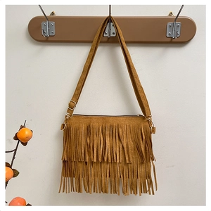 Detail of a brown fringe crossbody bag in faux suede with vintage bohemian style tassels