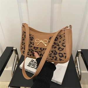 Chic leopard print shoulder bag with gold bow clasp and faux leather trim handle