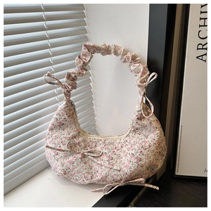 Detail of pink floral canvas bag featuring pleated ruffle handle and bow accents