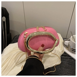 Detail of pink patent leather handbag with gold horseshoe handle and chain strap