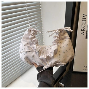 Detailed view of floral canvas hobo bag with pleated texture and adjustable bow drawstring
