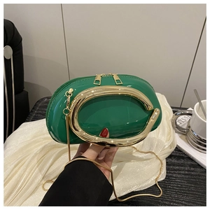 Macro view of green patent leather mini clutch with large gold U-shaped hardware