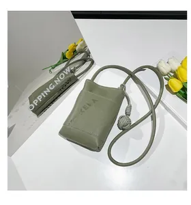 Detail view of mini sage green crossbody bag with textured leather and knot strap detail