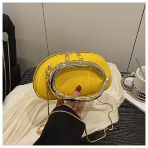 Detail of yellow patent leather handbag featuring oversized silver metal ring handle