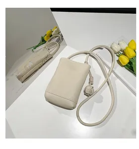 Detail view of beige lychee texture mini crossbody bag with a large decorative knot strap