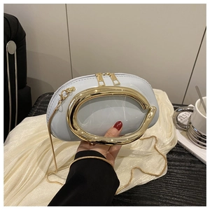 Detail of light blue glossy round bag with gold circular handle and metal chain strap