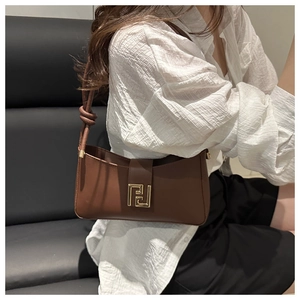 Detail of vintage brown shoulder bag with gold metal clasp and knotted strap detail