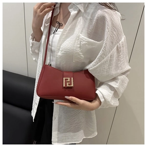 Close-up of deep red baguette bag with elegant gold geometric buckle for 2025 summer