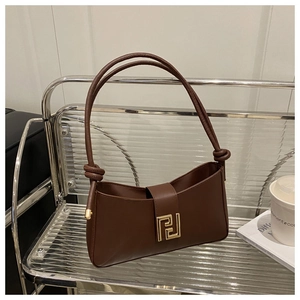 Detail of a dark brown shoulder bag featuring a unique gold geometric clasp and tied straps