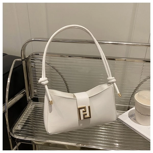 Detail of white leather baguette bag with knotted handle and golden buckle on chair