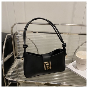 Detailed macro view of black leather shoulder bag with golden hardware and tied strap