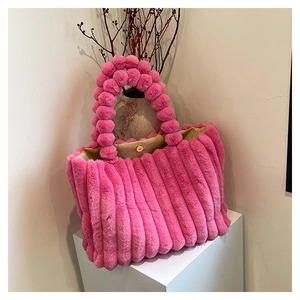 Detail view of pink plush tote bag showing soft faux fur texture and round pompom handle