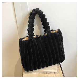 Detail of black plush tote bag featuring bubble handle and striped pleated texture finish