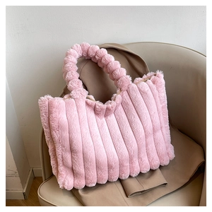 Detail of pink faux fur tote bag with vertical pleated texture and fluffy ball handle