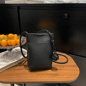 Minimalist black pebbled leather crossbody phone bag with stylish knotted shoulder strap detail