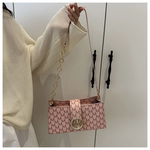 Detail of pink crossbody bag featuring M-letter print and golden metallic logo buckle