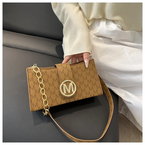 Detail of vintage brown leather bag with M-letter print and gold metal logo buckle