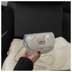 Close-up of a mini silver quilted crossbody bag with metal chain and turn-lock closure