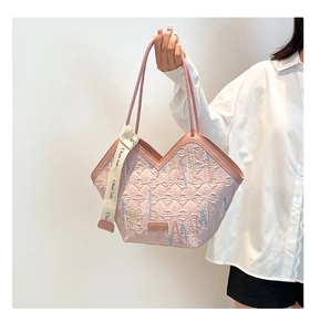 Detail of pink quilted tote bag with wave embroidery and elegant ribbon handle