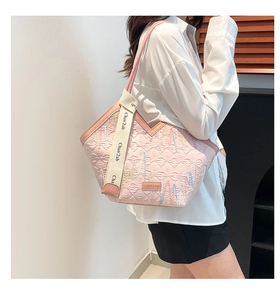 Detail of pink quilted handbag with colorful stitching and branded wide strap