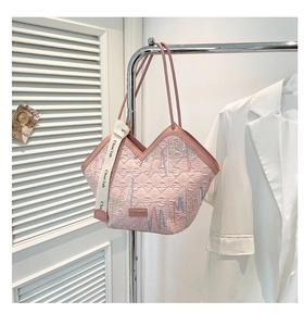 Detail of pink textured underarm bag with colorful zigzag stitching and V-cut design
